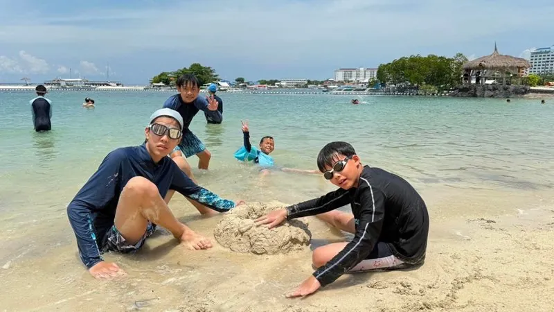 海辺で一緒に活動する子どもたち